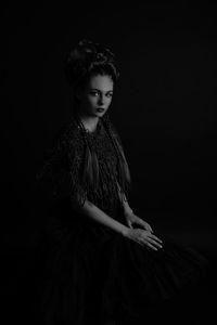 Young woman standing against black background