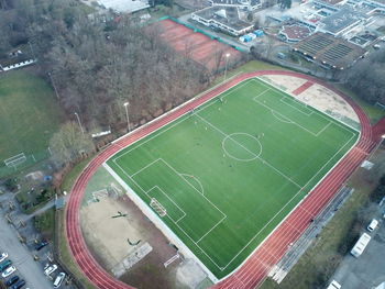 High angle view of soccer field by buildings in city