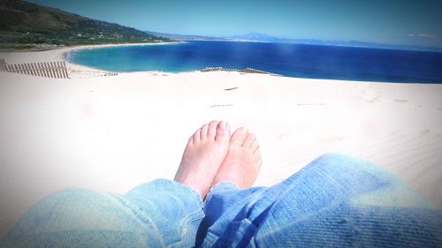 Low section of woman relaxing on beach