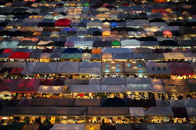 High angle view of people in illuminated market at night