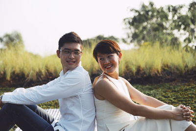 Portrait of smiling young couple on field