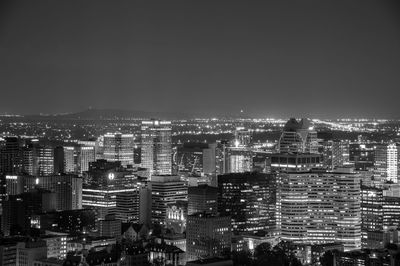 Illuminated cityscape against clear sky at night