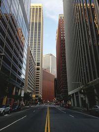 Road amidst buildings in city against sky