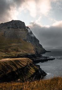 Scenic view of rocks by sea against sky