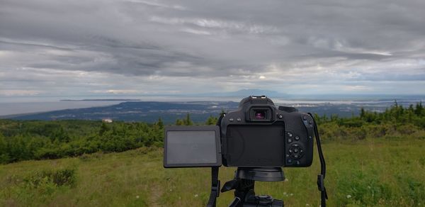 Vintage camera on landscape against sky