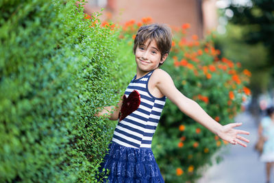 Portrait of smiling girl standing by plants