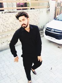 Young man looking away on footpath in city