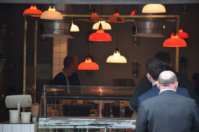 Rear view of people at illuminated table