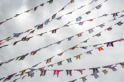 Low angle view of flags hanging against sky