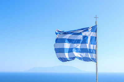 Low angle view of flag against blue sky