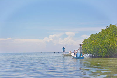 People on sea against sky
