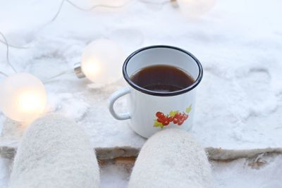 Tea mug, christmas lights on snow