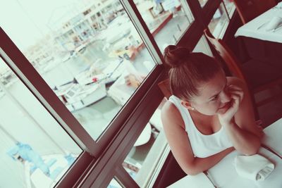 High angle portrait of girl looking through window