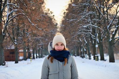 Portrait of smiling woman standing in snow