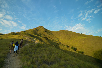 Rear view of hikers walking on mountain