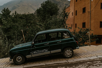 Vintage car on street against buildings in city