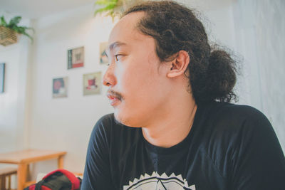 Close-up of young man sitting at home