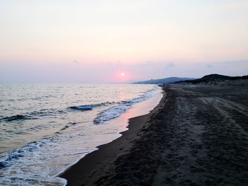 Scenic view of beach against sky during sunset