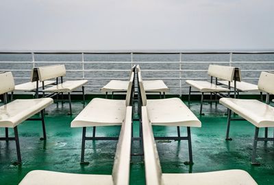 Empty chairs and table by sea