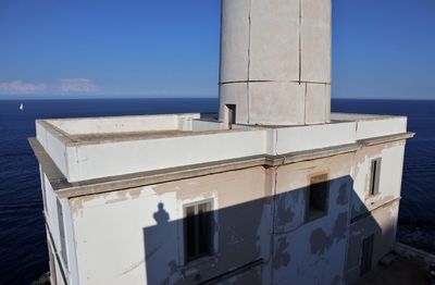 Built structure by sea against blue sky