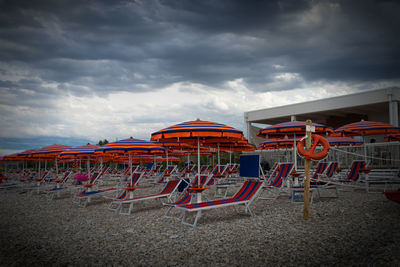 Chairs on beach against sky