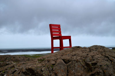 Lifeguard hut on rocks by sea against sky