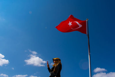 Low angle view of flag against blue sky