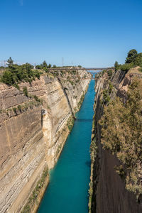 High angle view of river amidst trees against clear blue sky