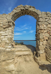 The arch of the ancient fortress of cape kaliakra above the sea against the background of the sky