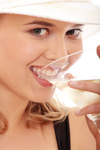 Close-up portrait of a smiling young woman drinking glass