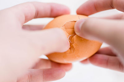 Close-up of hand holding heart shape against white background