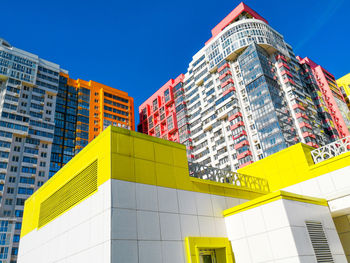 Low angle view of modern buildings against clear blue sky