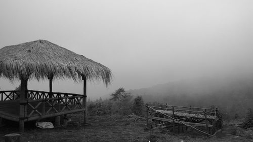 Gazebo on field against sky during foggy weather