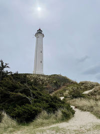 Lighthouse by sea against sky