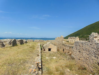 Scenic view of sea by buildings against blue sky