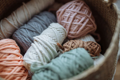 Beige wicker basket with multi-colored macrame threads