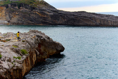 Rock formations by sea against sky