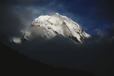 Low angle view of snowcapped mountains against sky