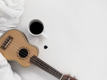 High angle view of guitar on table against white background