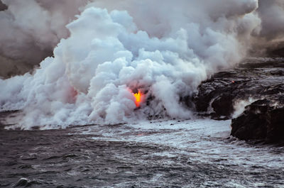 View of lava shining through smoke