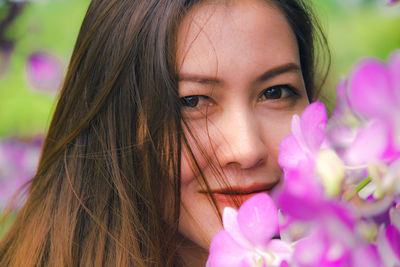 Close-up portrait of woman with pink flower