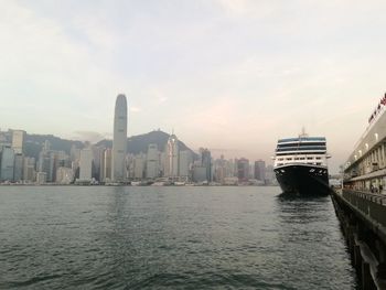 City at waterfront against cloudy sky