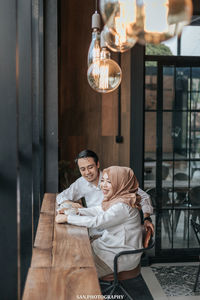 Young woman with drink on table at restaurant