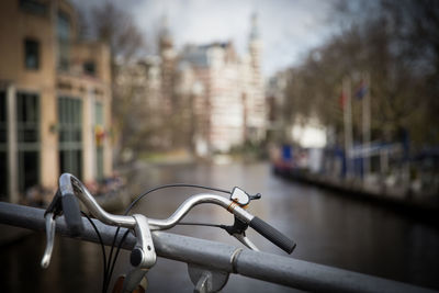 Bicycle parked by railing in canal