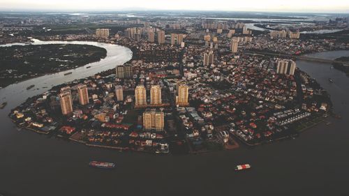 High angle view of illuminated city buildings by river