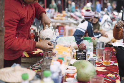 Midsection of vendor selling drinks at market stall