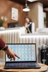 Midsection of woman using laptop on table