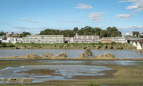 Scenic view of beach by buildings against sky