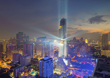 Illuminated cityscape against sky at night