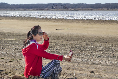 Side view of girl sitting on beach